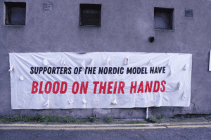 Supporters of the Nordic model have Blood on their hands on a banner